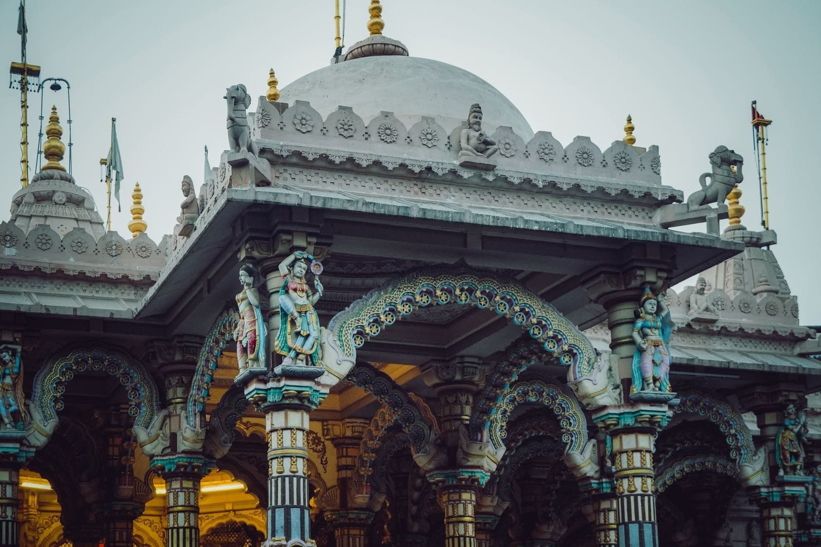 Intricate exterior of a Hindu temple showcasing colorful sculptures and detailed columns.