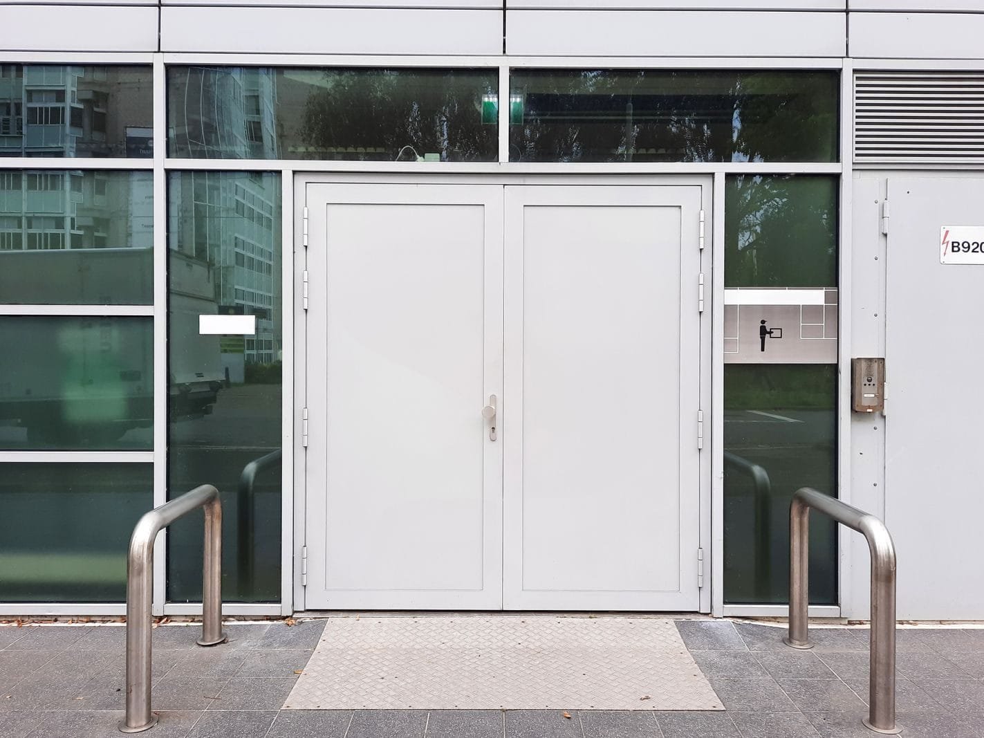 INSS fecha agências no Dia do Trabalhador em 1º de maio de 2026 1 Front view of a modern glass building entrance featuring double doors and sleek design elements.