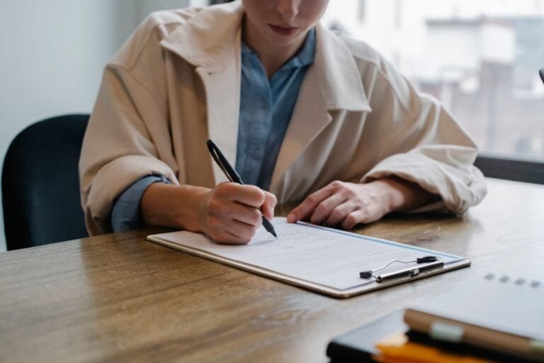 INSS proíbe pedido em duplicidade do mesmo benefício em 2026 5 Crop young female unemployed job seeker filling questionnaire sitting at table during interview in office