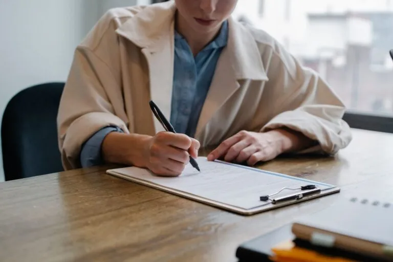 INSS proíbe pedido em duplicidade do mesmo benefício em 2026 4 Crop young female unemployed job seeker filling questionnaire sitting at table during interview in office