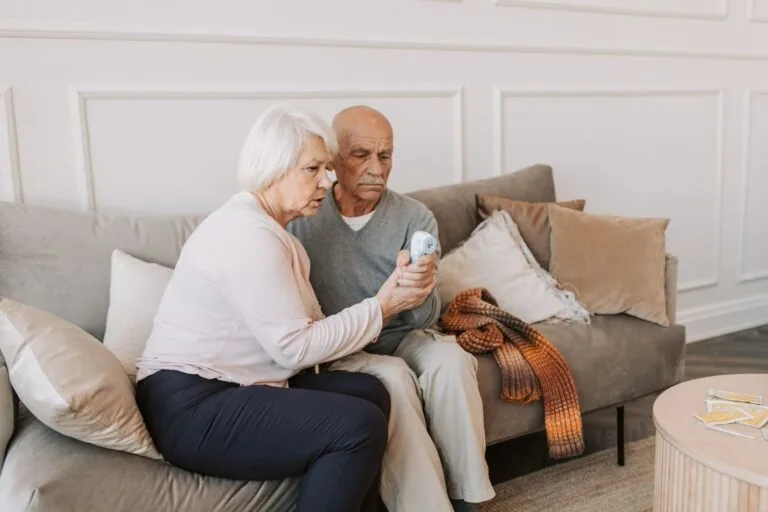 INSS ressarce R$ 2,54 bilhões a 3,72 milhões de aposentados e governo prorroga prazo de contestação de descontos indevidos para 14 de fevereiro de 2026 4 Elderly couple checking temperature with digital thermometer, highlighting health care at home.