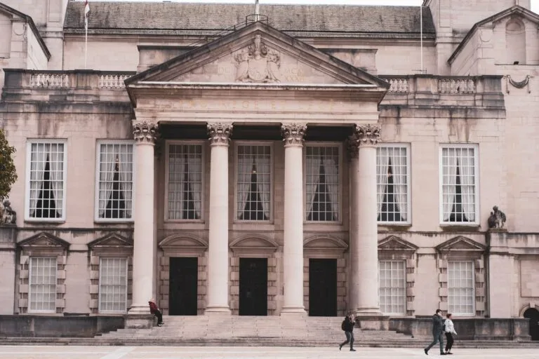 Classic architecture of a historic building in Leeds with people walking by.