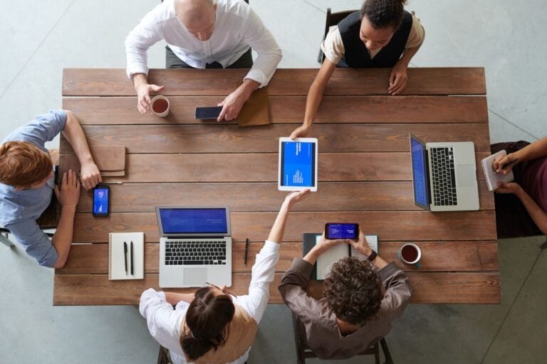 A diverse group of professionals engaged in a productive office meeting using digital devi