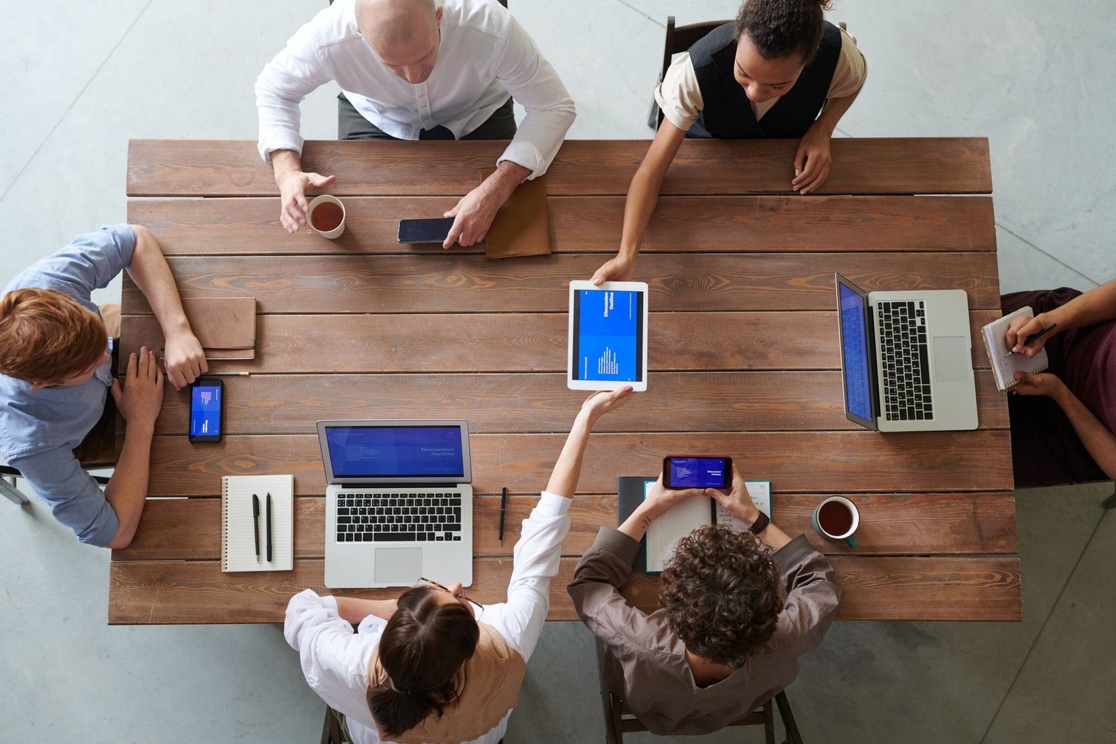 A diverse group of professionals engaged in a productive office meeting using digital devi