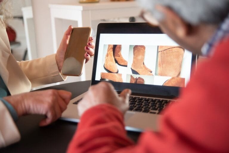 Loja virtual fantasma: como reconhecer fraudes e o que fazer após cair em uma 4 Two people shopping for shoes online using a laptop and smartphone at home.