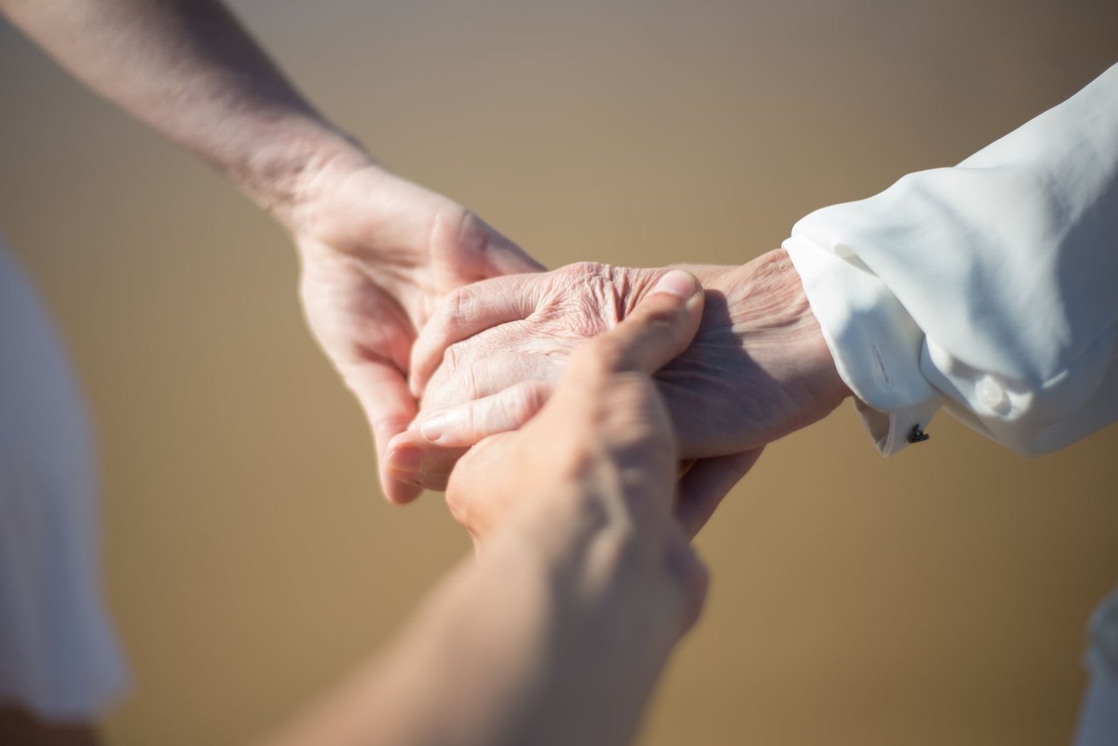 Pensao por morte para filhos: idade limite e excecoes importantes 1 Gentle close-up of intergenerational hands holding, symbolizing connection and care.
