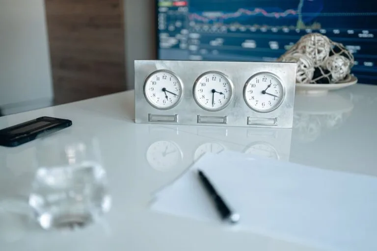 Prazos no processo administrativo: quando o silêncio da Administração vira direito 5 Professional workspace featuring three clocks and financial data on screen.