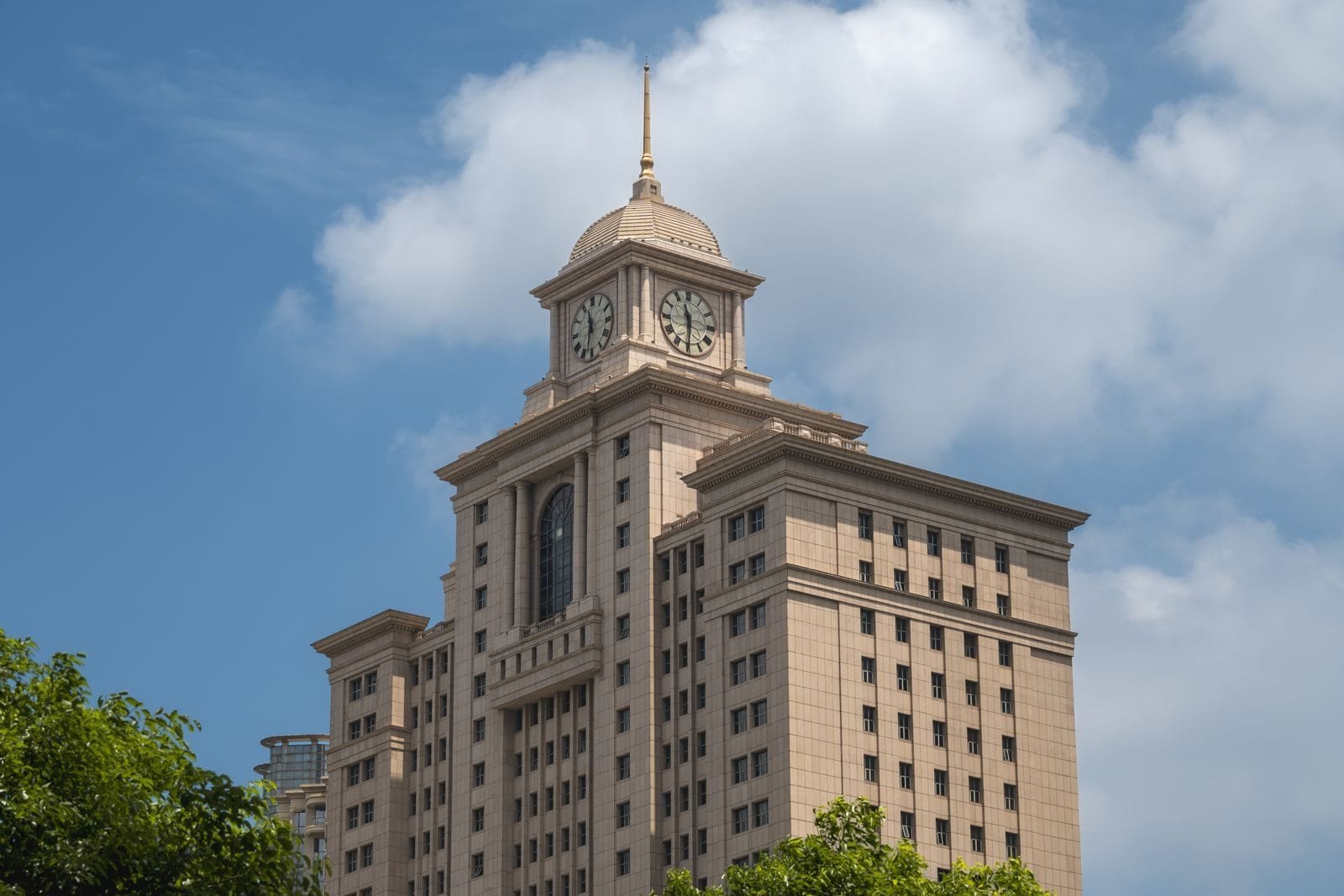 Prescrição no Direito Administrativo: Prazos e Regras 1 Elegant clock tower atop a government building, framed by clear blue sky and clouds.