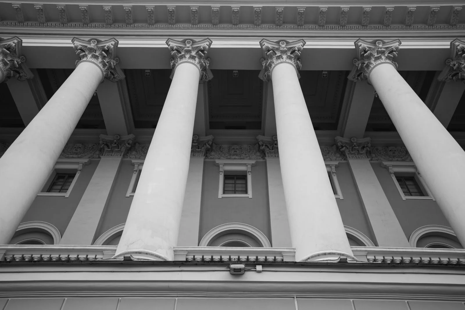 Princípios da Administração Pública: O Que Significa LIMPE 1 Black and white image showcasing majestic classical columns of a historic building facade.