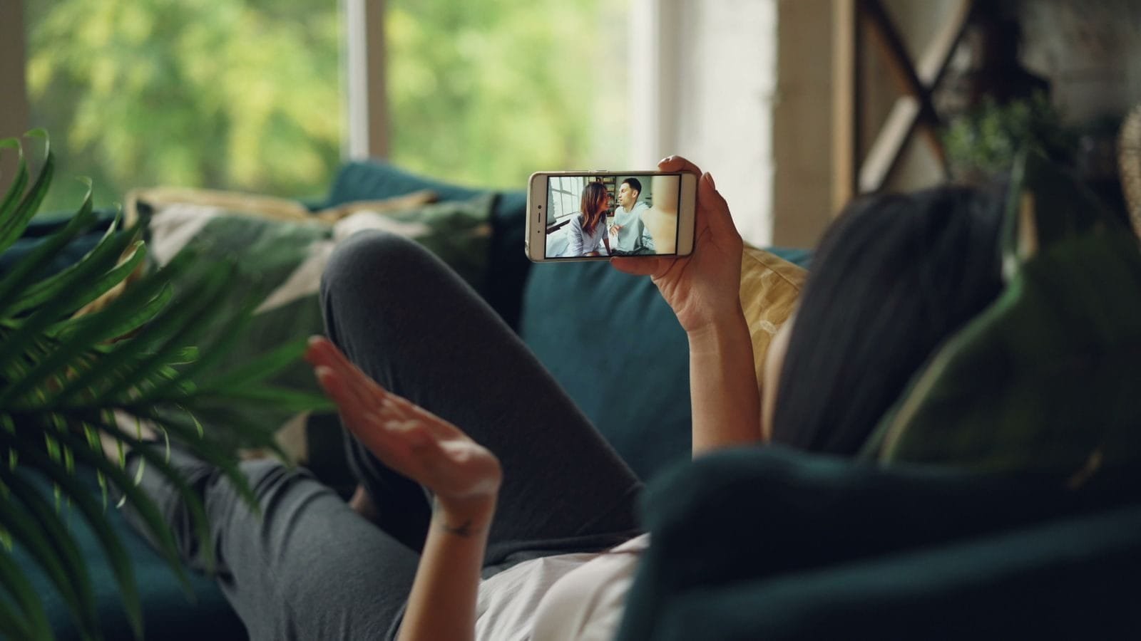 Print de conversa vale como prova: o que torna a evidencia valida 1 Woman relaxing on a couch, engaged in a video call on her smartphone, indoors.