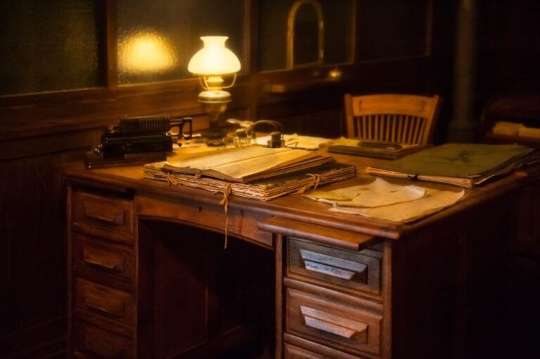 Como podemos ajudar? 3 Cozy vintage office setting with an antique typewriter, lamp, and paperwork on a wooden desk.