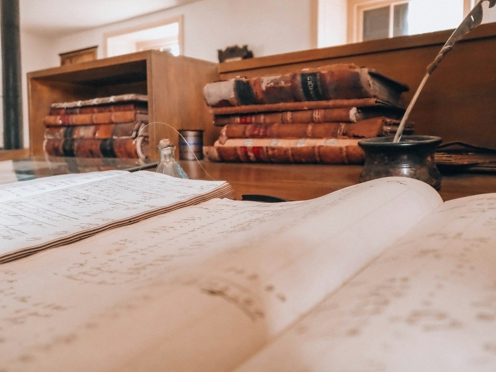 Provas digitais: como preservar mensagens e arquivos que sustentam o seu direito 1 Open book, old books, and a quill on a desk.