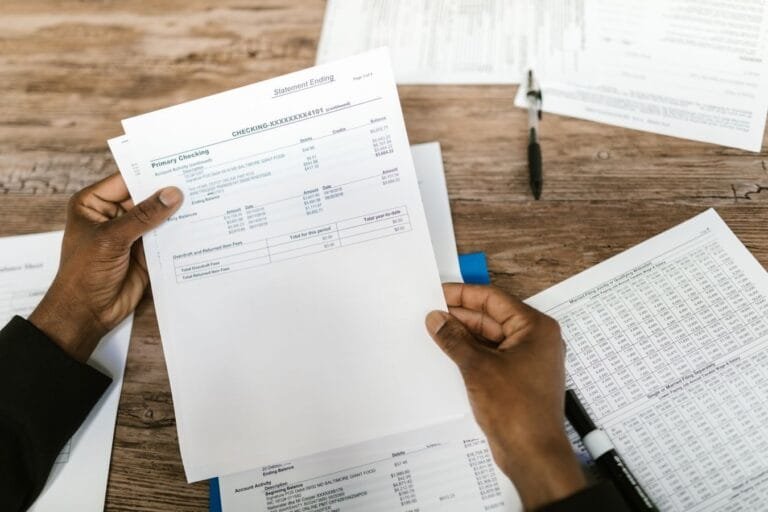 Receita Federal regulamenta parcelamento excepcional de débitos previdenciários de municípios e consórcios públicos em até 300 parcelas (IN RFB nº 2.283/2025) 4 Hands holding financial papers for tax preparation and analysis.