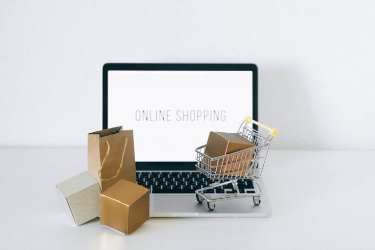 Receptacao: o risco de comprar produto de origem duvidosa 3 Laptop displaying online shopping with boxes and cart, representing ecommerce.
