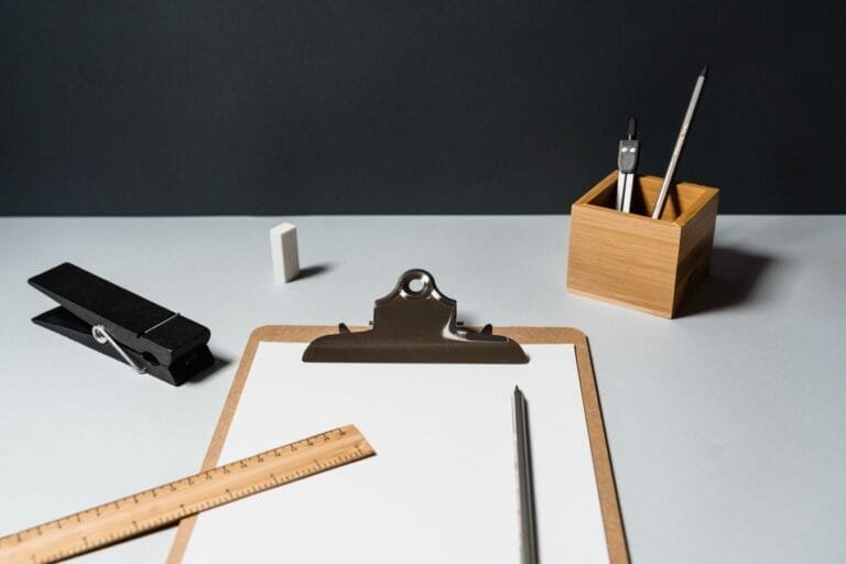 A minimalist office desk setup with essential office supplies on a dark background.
