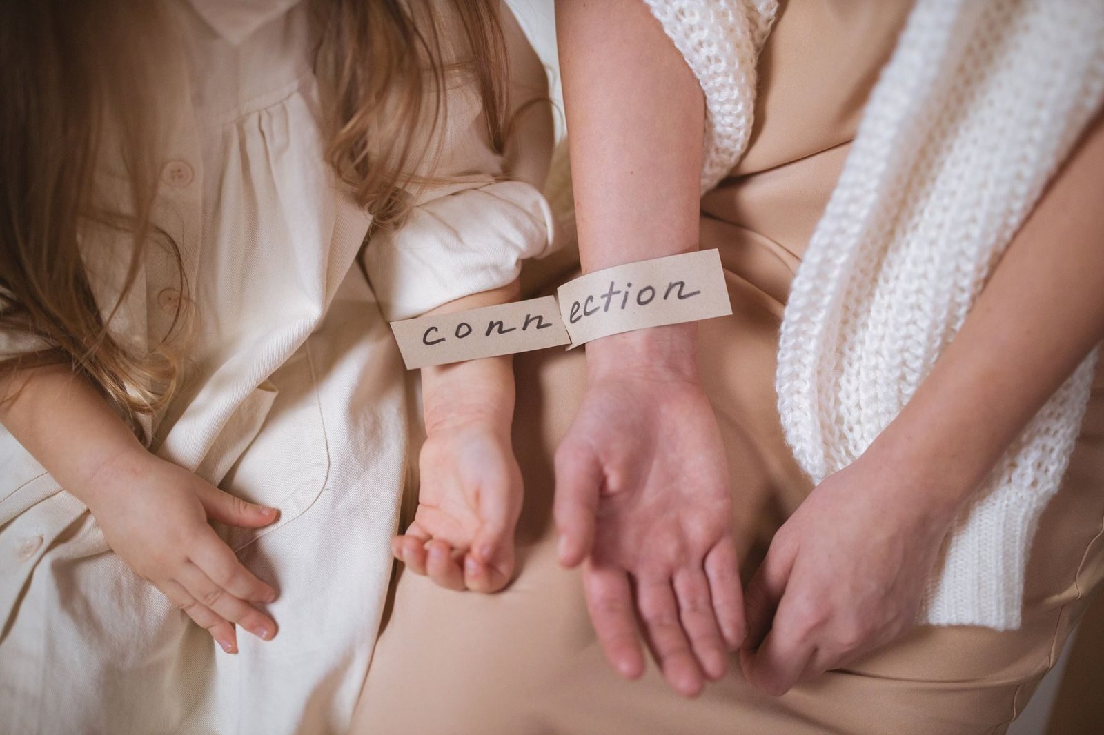 A mother and child showcasing the theme of connection with a label on their wrists.