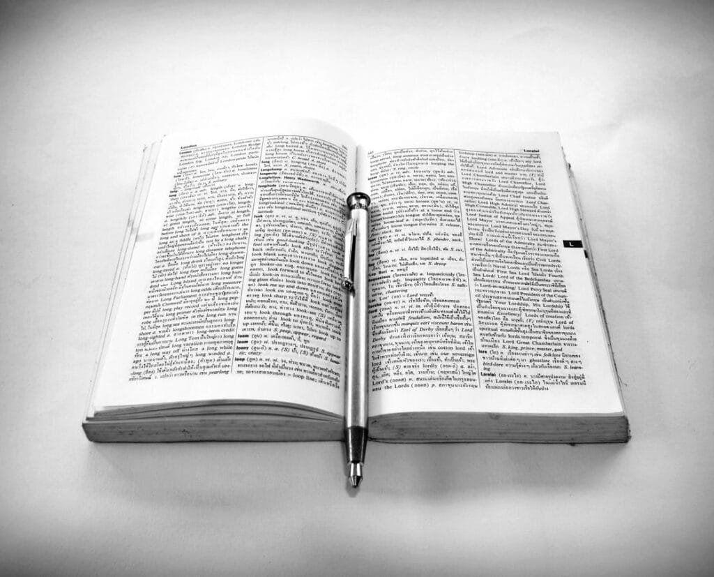 Minimalist black and white image of an open Bible with a pen, symbolizing study and reflection.