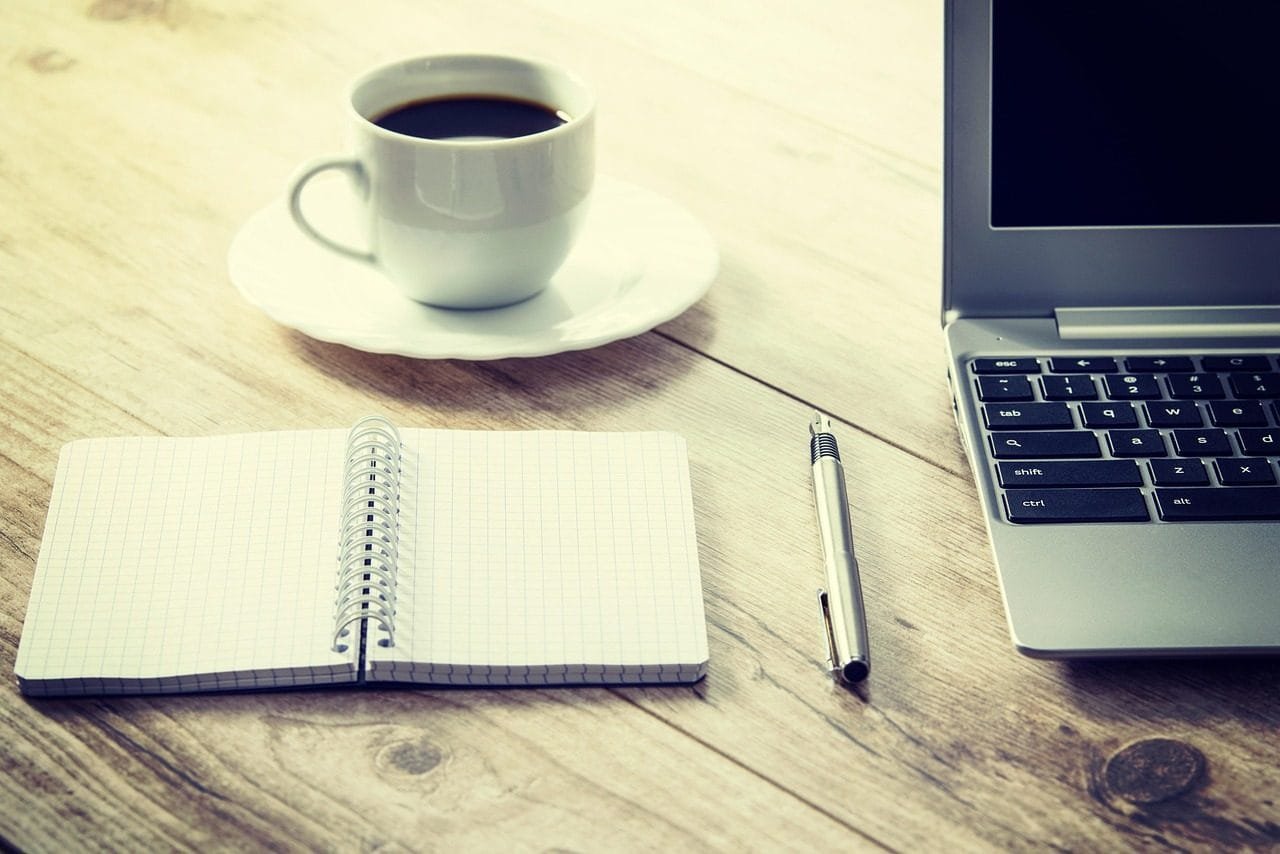 coffee, computer, cup, desk, drink, laptop, notebook, pen, table, wooden table, coffee cup