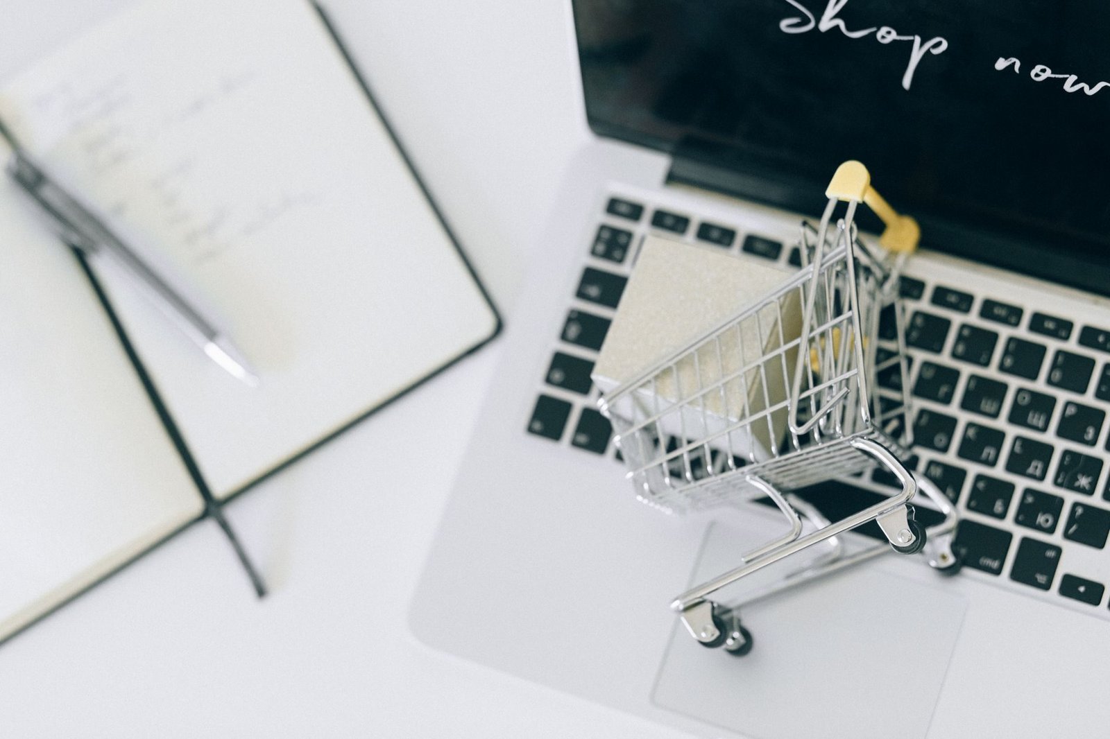 Superendividamento: como repactuar dívidas e preservar o mínimo existencial 1 Creative depiction of online shopping with a miniature cart on a laptop keyboard.
