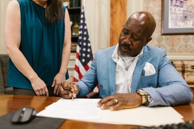 Professional lawyer signing documents in an elegant law office setting, showcasing a serious work environment.