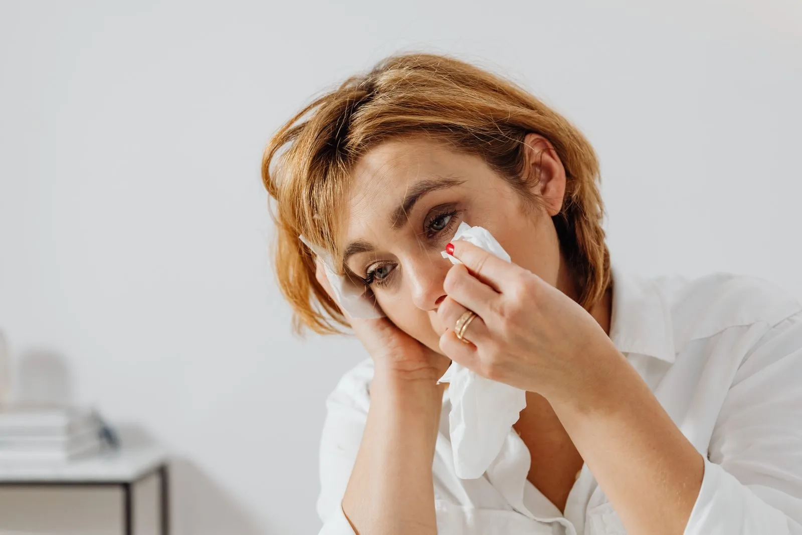 Portrait of woman holding tissue, expressing emotion, wiping tears.