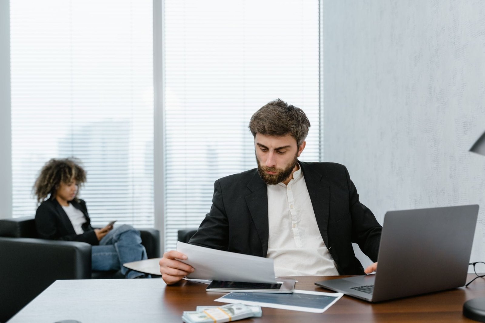 Verba de representação do bancário: salarial ou indenizatória 1 Focused businessman reviews financial reports at office desk with laptop.