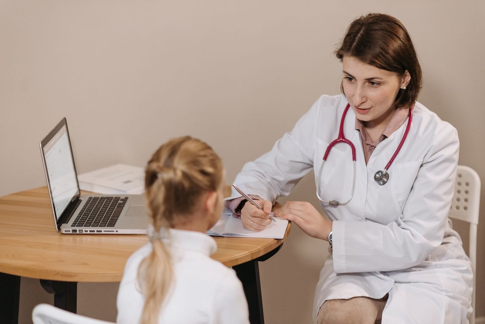 A female doctor listens attentively to a young girl during a medical consultation in an of