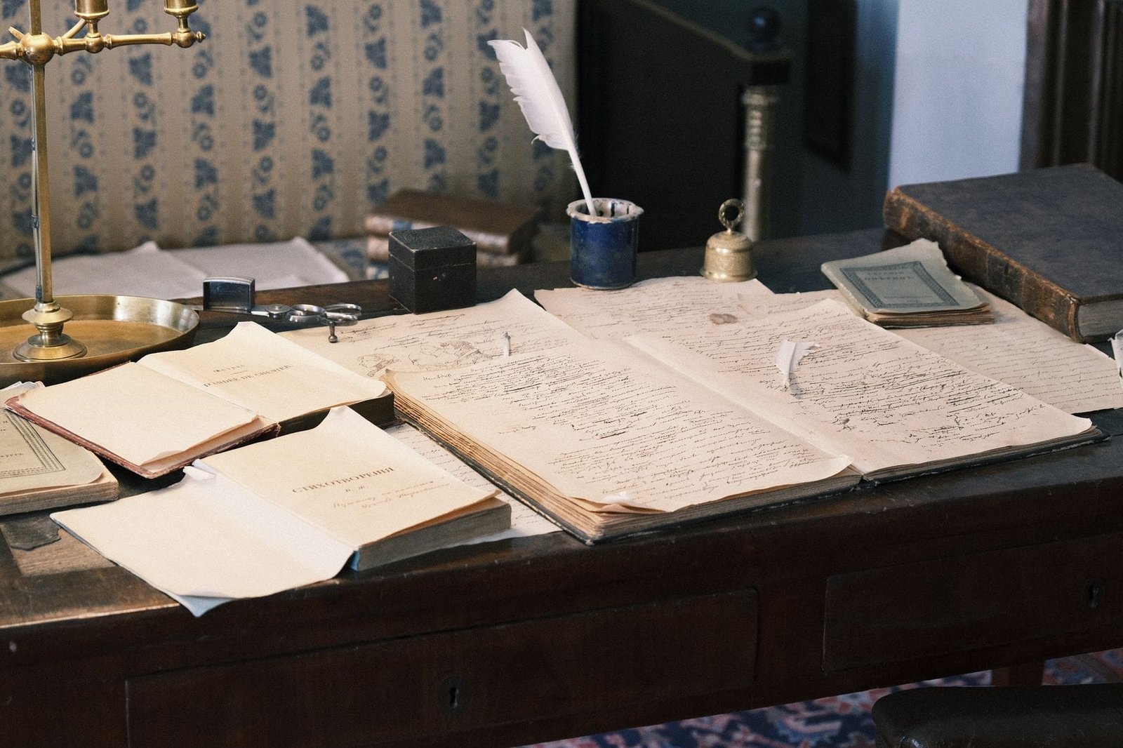 Cozy study with vintage desk, open books, and quill for a classic literary feel.