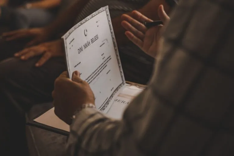 Close-up of a person holding a wedding certificate in a formal ceremony setting.