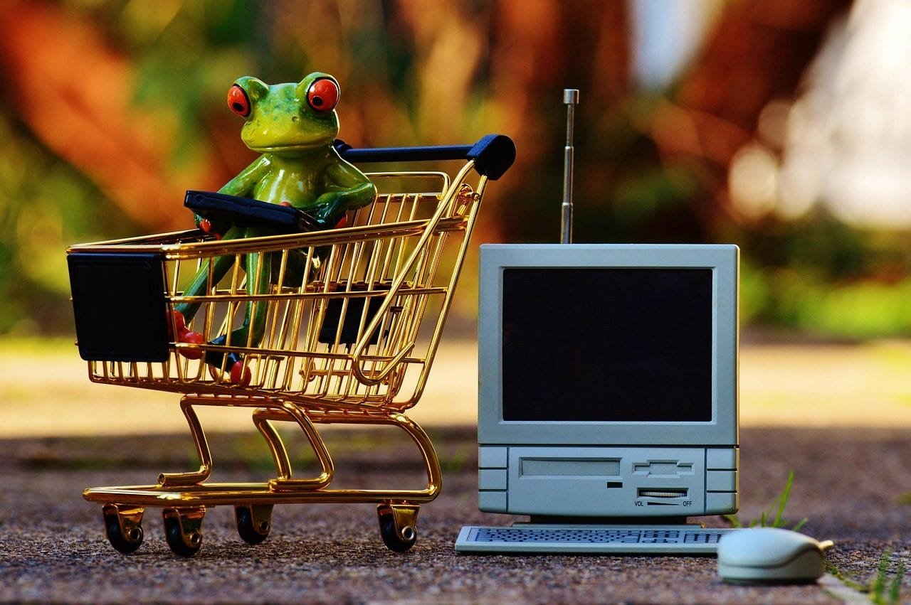 Produto com vício ou defeito: prazos de troca, conserto e devolução no CDC 1 Carrinho de compras em miniatura ao lado de um computador antigo