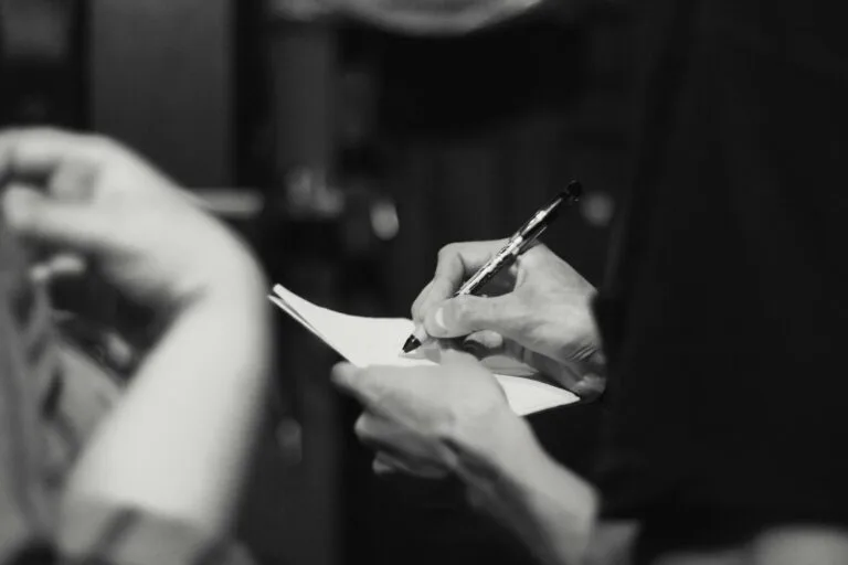 person writing on note