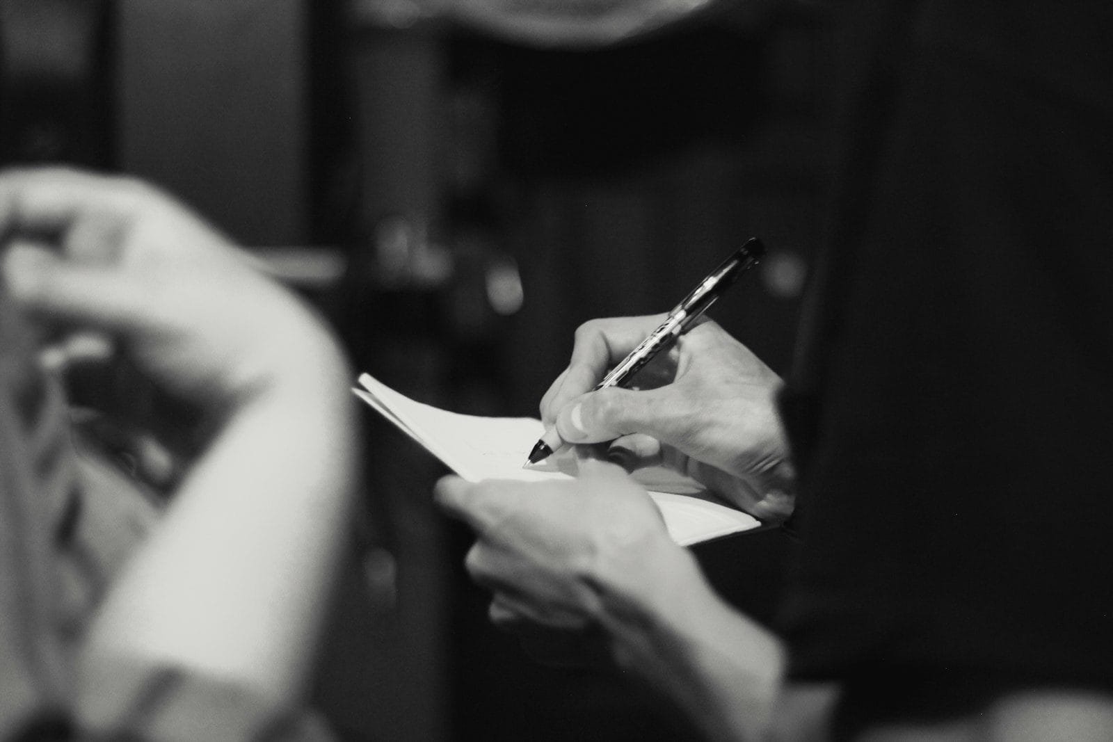 person writing on note