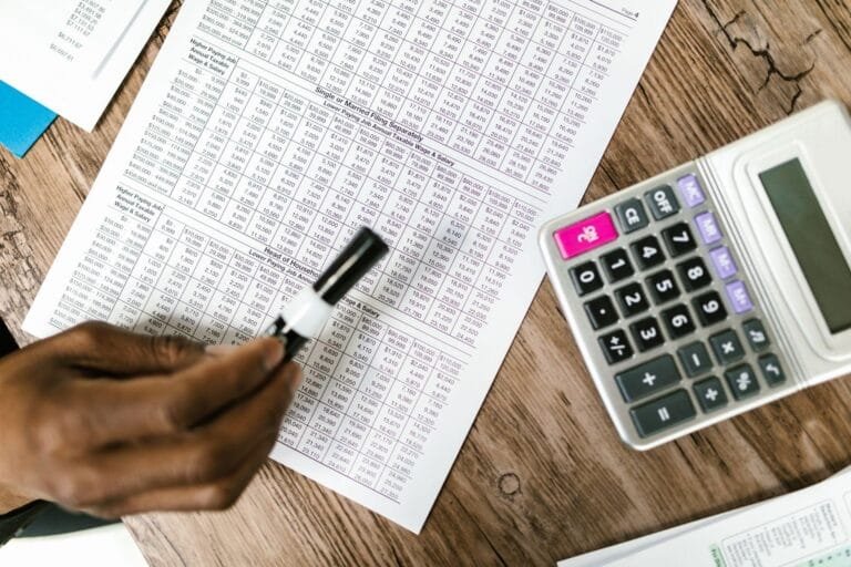 Pessoa confere planilhas e utiliza calculadora